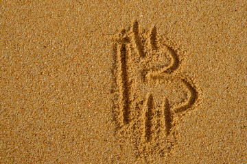 Bitcoin sign written on sand in evening sunlight