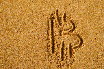 Bitcoin sign written on sand in evening sunlight