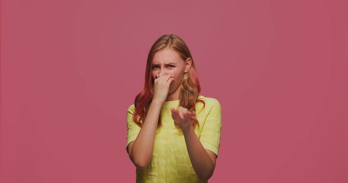 Repulsion to bad smell. Girl close nose with hands to avoid stink, intolerable disgusting odor, showing stop gesture