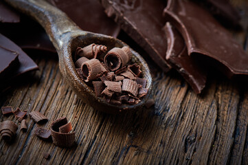 dark chocolate over wooden backround with some cocoa powder