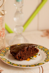 a piece of chocolate cake with chocolate on top on an openwork plate