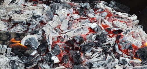 Hot coals and ash. Hot firewood in the grill. Grilling coals.