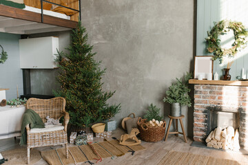 The interior of a country house with a fireplace, a Christmas tree, a wicker chair and decor for...