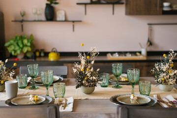 A beautiful festive dining table in the rustic style. Dried flowers in a ceramic vase on the table
