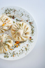 Georgian khinkali with meat on the white background with spices