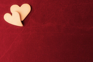 Fototapeta premium Two hearts on red stone background with copy space. Valentines day background