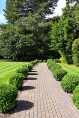 Landscaped grounds with a paved footpath past lawns and trees. No people.