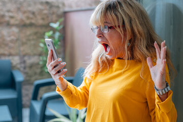 surprised woman with mobile phone at home