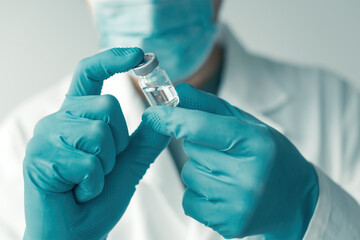 Medical professional holding booster shot Covid-19 vaccine bottle vial - obrazy, fototapety, plakaty