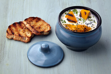 Pumpkin cream soup with cream, black cumin seeds, herbs