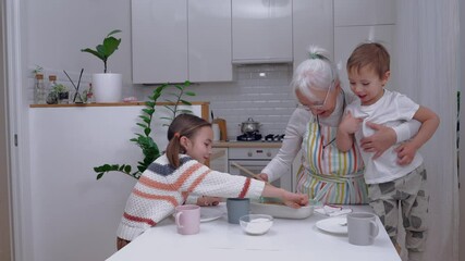 Brother and sister visiting their grandmother, they cook together in the kitchen