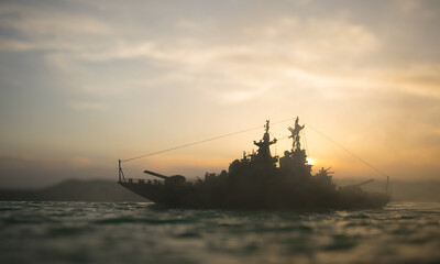 Silhouettes of a crowd standing at blurred military war ship on foggy background. Selective focus.