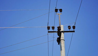 Close-up high voltage power line on a background of blue sky on a sunny day. Electro pole, pole...