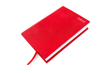 Closed red notebook with the words 2022 and a ribbon, isolated on a white background.