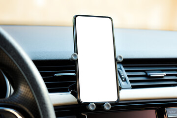 Obraz na płótnie Canvas phone holder attached to the ventilation grille in the vehicle and a phone with a white screen on it