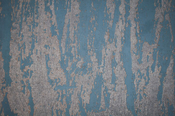 A sheet of gray plywood with old crumbling blue paint