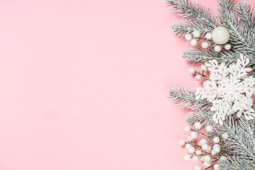 Christmas pink flat lay background. Fir tree and white christmas decorations top view with copy space.