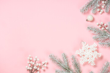 Christmas decorations at pink background. Fir tree and white christmas decorations top view with copy space.