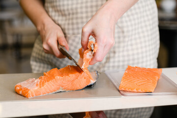 Removing fish bones. Butchering red fish meat.