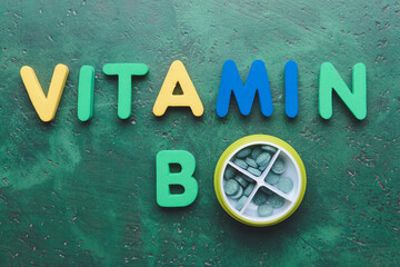 Text VITAMIN B with pills on color background