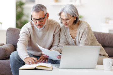Worried senior family reading financial documents or notification letter with bad news from bank