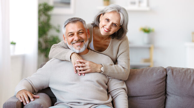 Beautiful smiling senior family couple husband and wife looking at camera with love