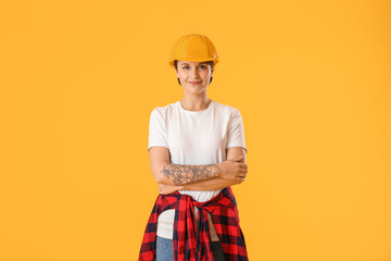 Female construction worker in hardhat on yellow background