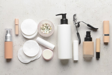 Different decorative cosmetics and cotton pads on light background
