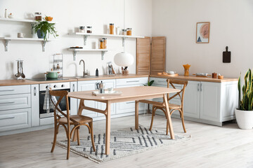 Stylish kitchen interior with wooden dining table