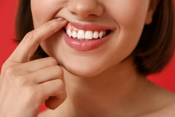 Obraz premium Young woman with healthy gums on color background, closeup