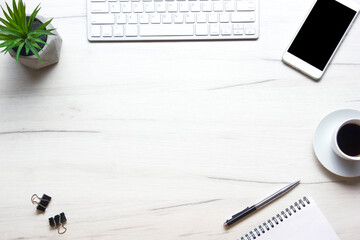 White desk office with laptop, smartphone and other work supplies with cup of coffee. Top view with...