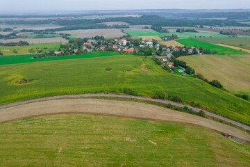 The field is plowed by a tractor near the railway. Sowed green manure in a field near the village.