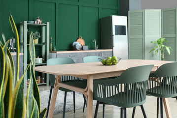 Dining table with green apples in stylish kitchen