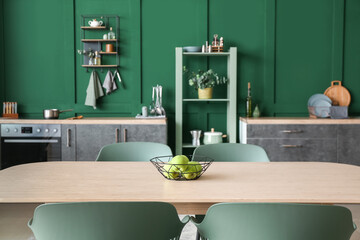 Dining table with green apples in stylish kitchen
