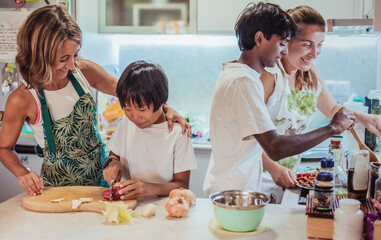 a multiracial chinese and indian multiracial family, having fun cooking together at home. concept of lesbian couple and multiracial family. Adoption. inclusion and diversity