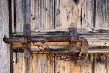 Close-up of a metal old fashioned latch on an old wooden door