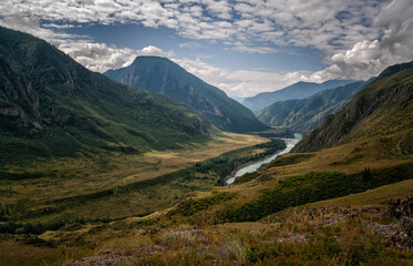 panorama of the summer landscape in the mountains. The valley of the mountain river Katun turquoise. the river flows between mountains and wide fields. blue sky and clouds view from high point