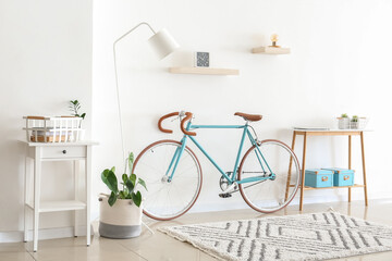 Interior of light living room with bicycle and table