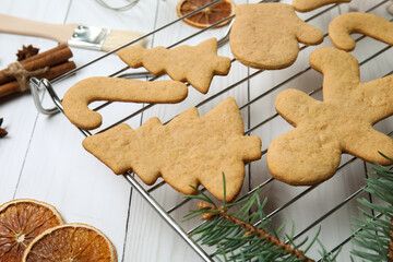 Fototapeta premium Grid with Christmas gingerbread cookies and spices on light wooden background, closeup