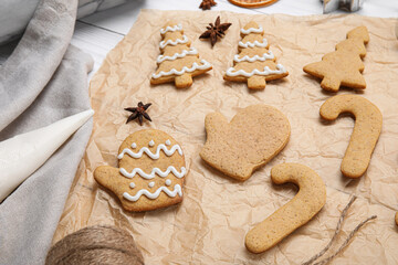 Parchment with Christmas gingerbread cookies on table, closeup