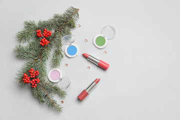 Christmas composition with lipsticks and eyeshadows on light background