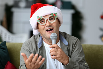 Mature man with microphone singing Christmas song at home