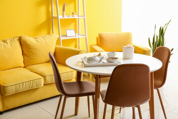 Interior of bright yellow dining room with table