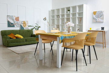 Interior of modern dining room with table, chairs and sofa