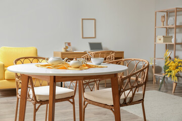 Dining table with wicker chairs in modern room