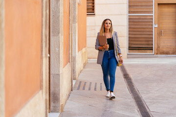 Freelancer with laptop walking in street