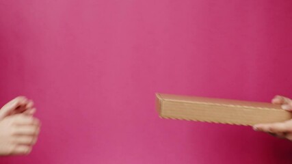 Square cardboard box on pink background. Preparing take away meals. Online contactless food shopping. Food delivery service. Courier taking order, delivering to customer. 