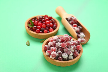 Composition with bowls of sugared cranberry on green background