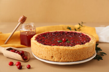 Plate with tasty lingonberry pie and jam on color wooden table