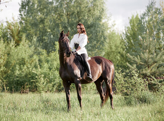 Beautiful long-haired girl riding a horse